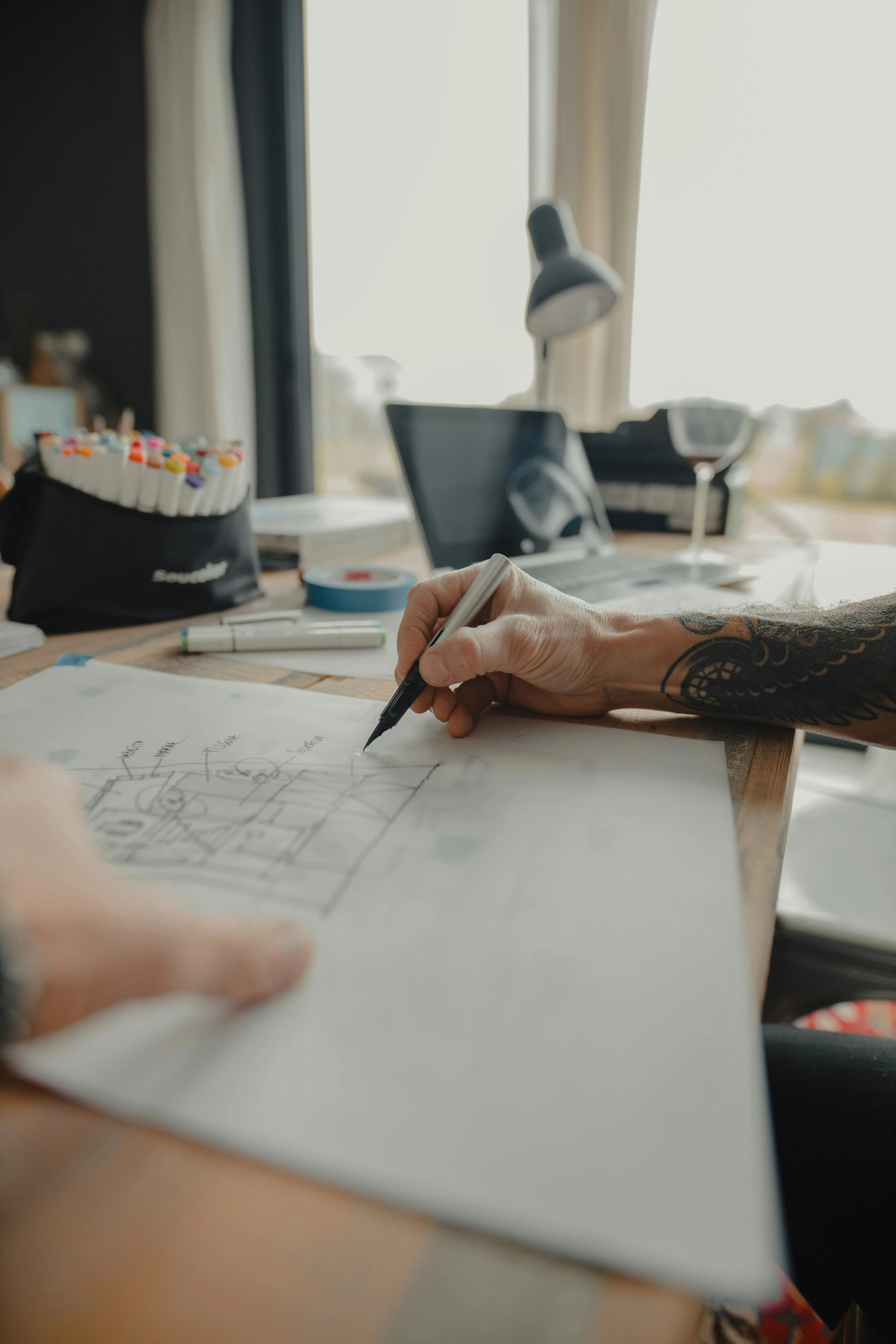 Designer sketching wireframes at a creative workspace